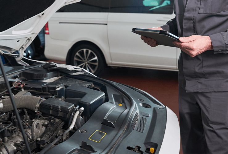 A mechanic looking at a car's engine