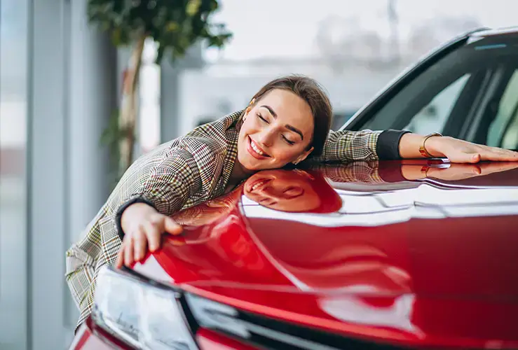 A woman hugging a car