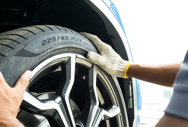 Hands of a mechanic on the tyre to check tyre information 
