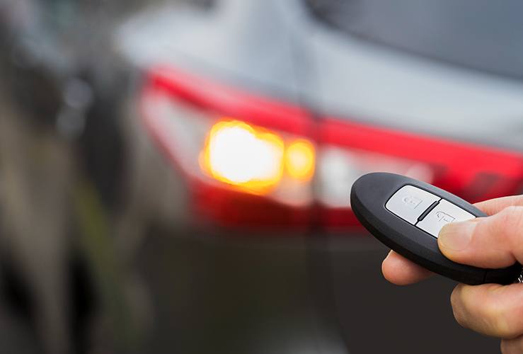 Person unlocking a car using a car key