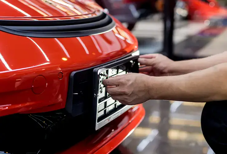 A number plate being fitted to a car