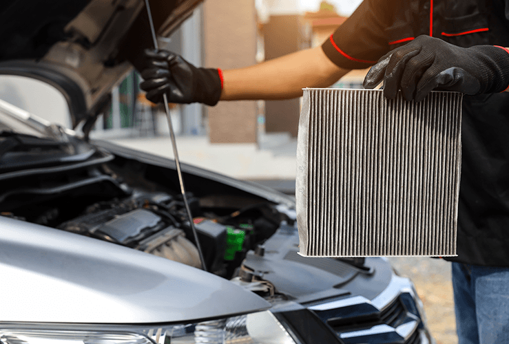 A mechanic cleaning out the filter of the air con