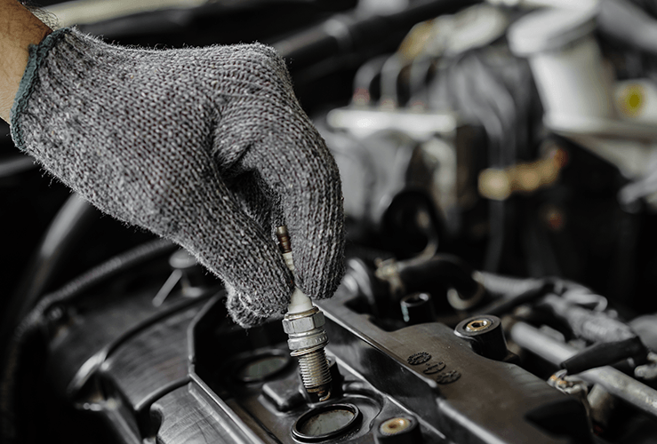 A person replacing spark plugs