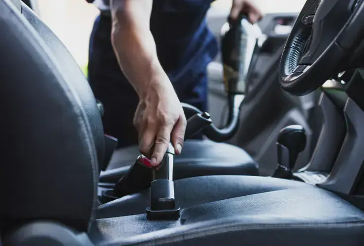 Person vacuuming car