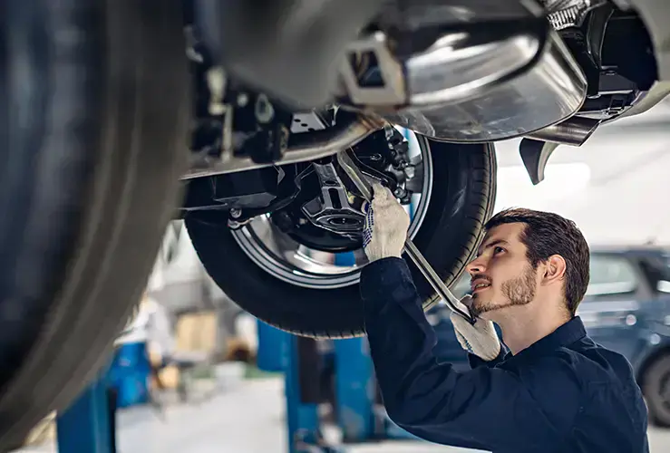 A mechanic looking underneath a car