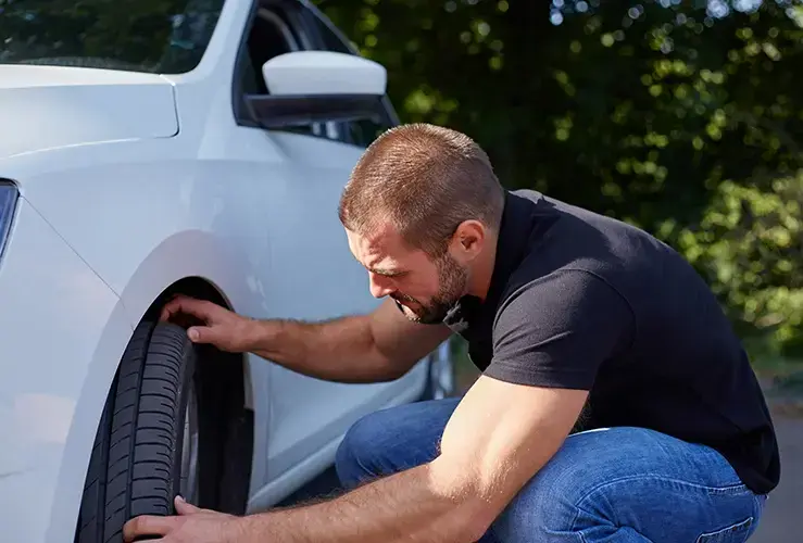 Man checking tyres on new car