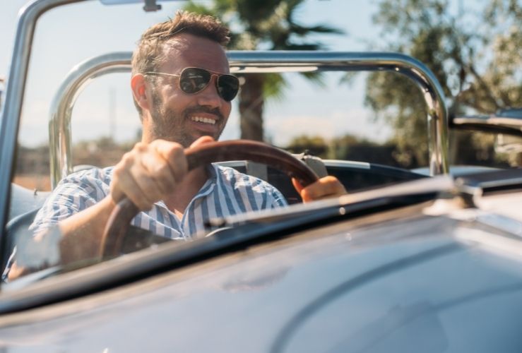 Man driving convertable classic car