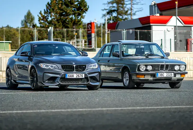 An old car and a modern car next to each other