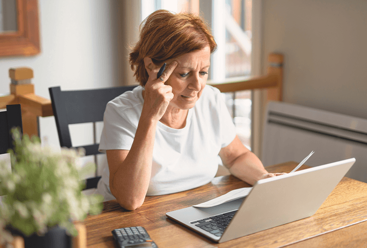 A woman looking stressed at her laptop