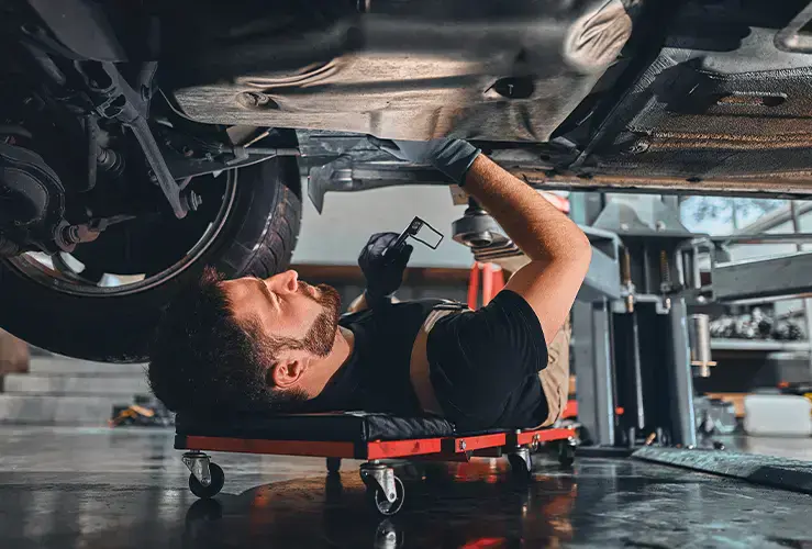 A mechanic working underneath a car